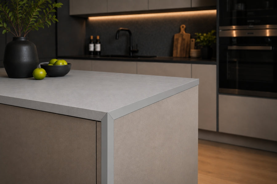 Light grey PVC corner trim finishing the edge of a kitchen island with a contrasting pale worktop and neutral cabinetry.